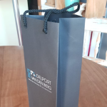 Narrow black matte wine bag featuring a two-color (blue and white) silkscreened logo.