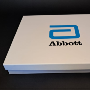 Large white rigid box with a custom grey foam insert and multi-component branded items.
