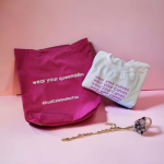 Branded magenta fabric tote bag displayed alongside a white sweatshirt with matching magenta typography.
