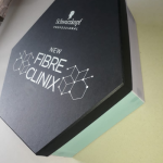 Hexagon-shaped black rigid box with white silk-screened branding and a mint green base.
