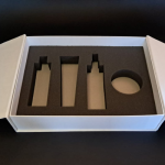 Close-up of complex, flame-shaped die-cut foam inserts and precision-cut cosmetic bottle recesses.