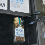 Close-up of a glass bottle with coffee beans nestled in a velvet-lined insert with a satin ribbon.