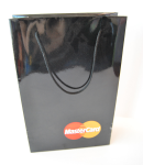 Small white high-gloss paper bag with blue braided rope handles and multi-colored brand striping.