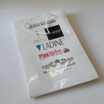 White high-gloss paper bag with white cord handles and multiple corporate logos