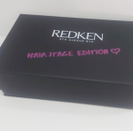 Closed black hinged lid box with two-color (white and pink) silk-screened branding.