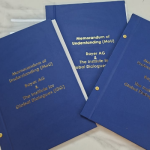 Royal blue document covers with centered gold foil typography.