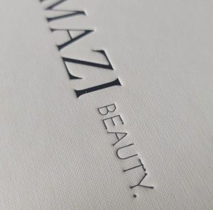 Detailed view of blue foil stamping on a white textured paper.