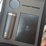 Grey high-density foam insert with precision die-cut cavities for a tumbler, notebook, and pen.