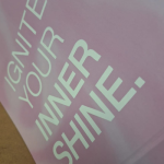 Gloss White Text silk-screen branding on printed pattern paper.