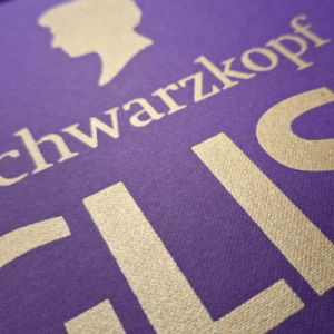 Gold metallic foil branding and icons on a matte purple textured paper.