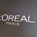 White silk-screened branding on a heavily textured black paper substrate.