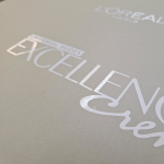 Close-up of gloss white vinyl branding applied to a matte grey surface.