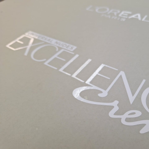 Close-up of gloss white vinyl branding applied to a matte grey surface.